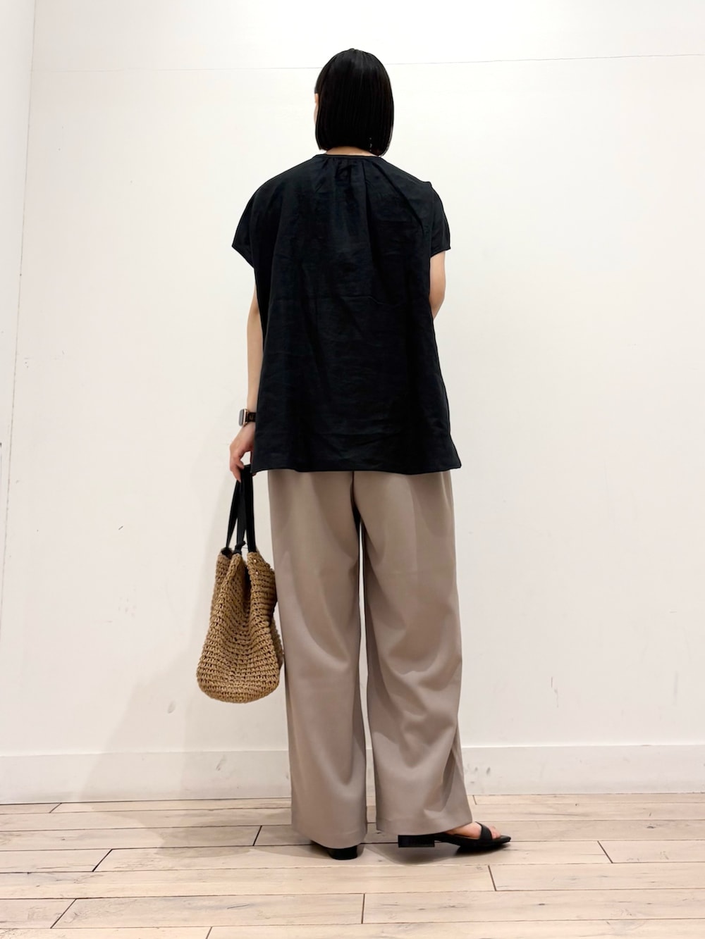 ブラック系のシャツ/ブラウス、イエロー系のかごバッグ、ベージュ系のその他パンツを着用したレディースの春コーディネートの4枚目の写真