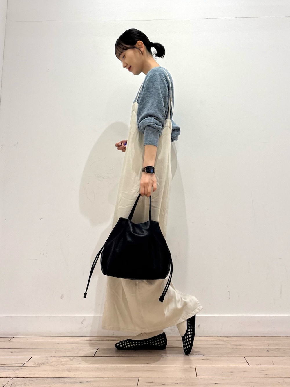 ブルー系のニット/セーター、ブラック系のショルダーバッグ、ブラック系のサンダルを着用したレディースの春コーディネートの2枚目の写真