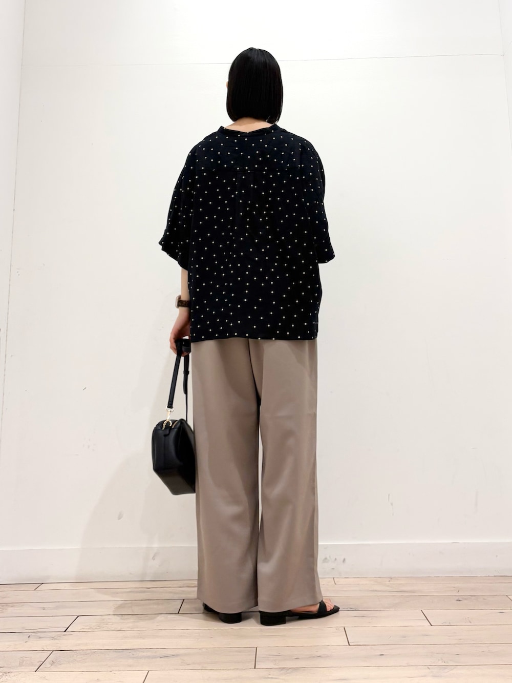 ブラック系のシャツ/ブラウス、ベージュ系のその他パンツ、ブラック系のショルダーバッグを着用したレディースの春コーディネートの5枚目の写真