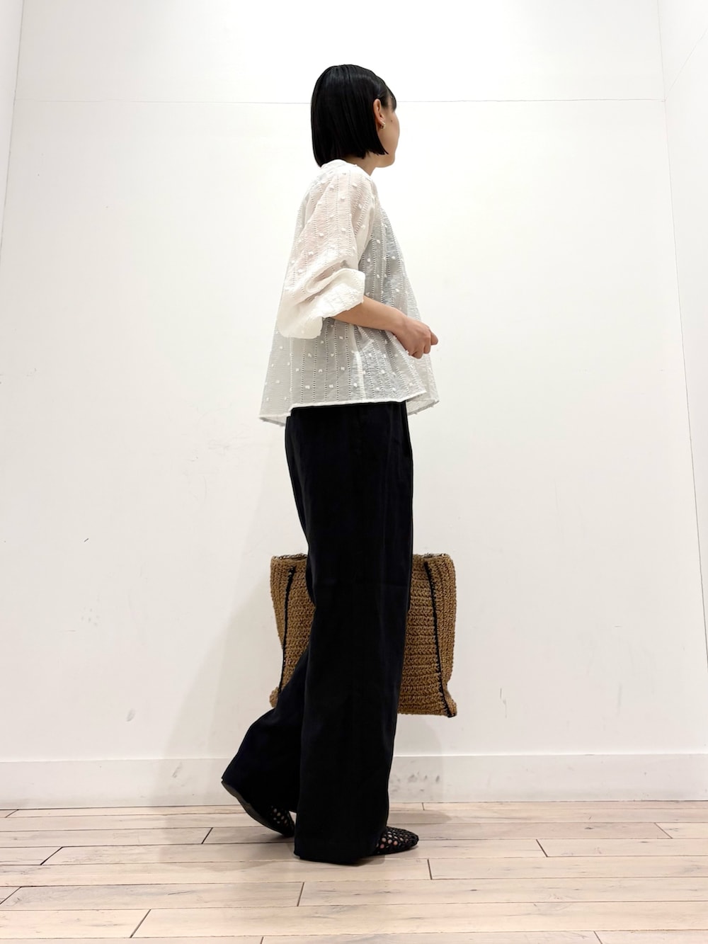 ホワイト系のシャツ/ブラウス、ブラック系のその他パンツ、ベージュ系のトートバッグを着用したレディースの春コーディネートの4枚目の写真