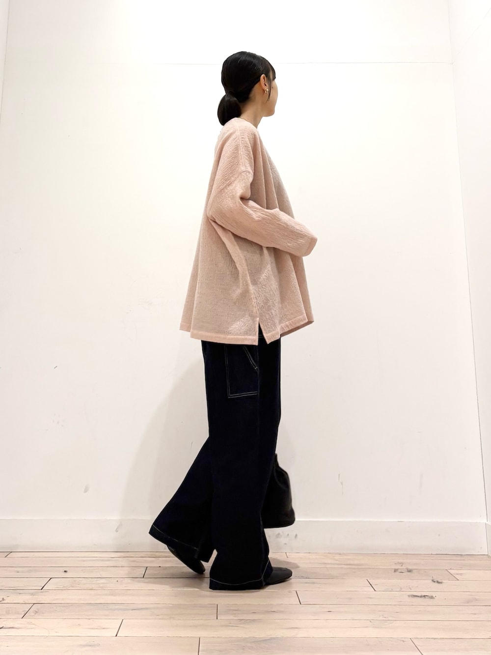 ピンク系のシャツ/ブラウス、ブルー系のデニムパンツ、ブラック系のショルダーバッグを着用したレディースの秋コーディネートの4枚目の写真