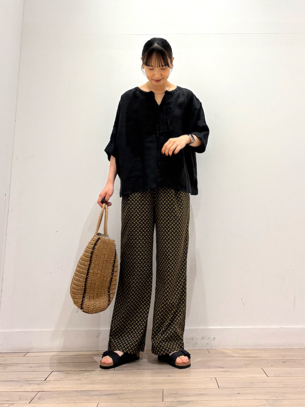 ブラック系のその他パンツ、ベージュ系のトートバッグ、ブラック系のサンダルを着用したレディースの夏コーディネートの2枚目の写真