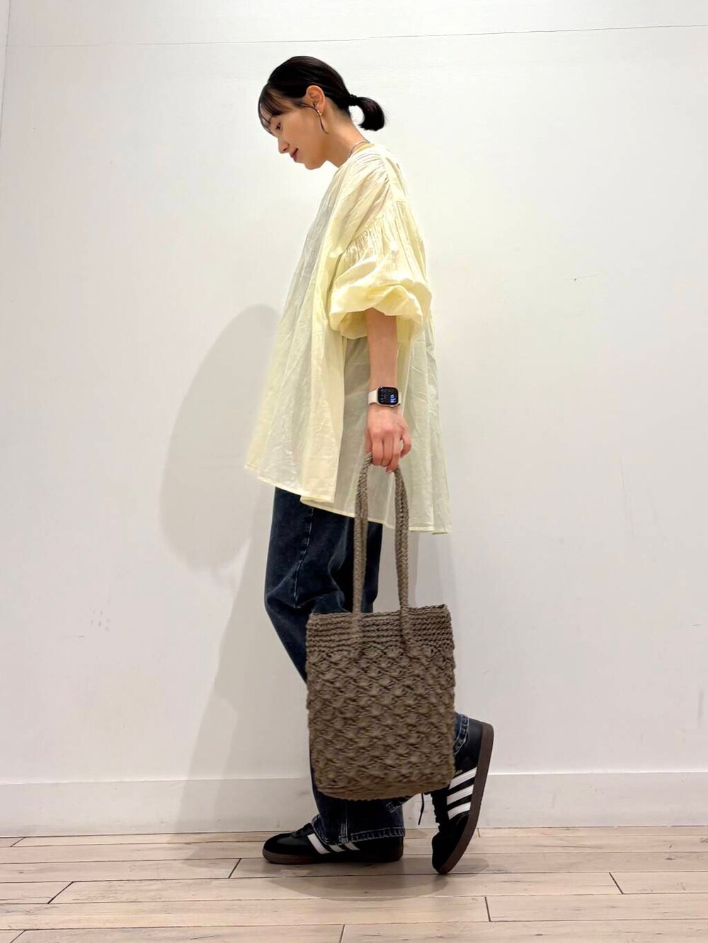 ブルー系のデニムパンツ、グレー系のトートバッグ、イエロー系のシャツ/ブラウスを着用したレディースの春コーディネートの3枚目の写真