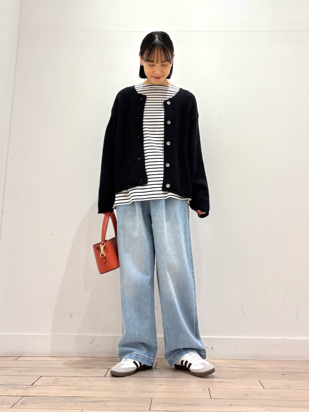 ブラック系のカーディガン/ボレロ、ブルー系のデニムパンツ、ホワイト系のスニーカーを着用したレディースの冬コーディネートの2枚目の写真