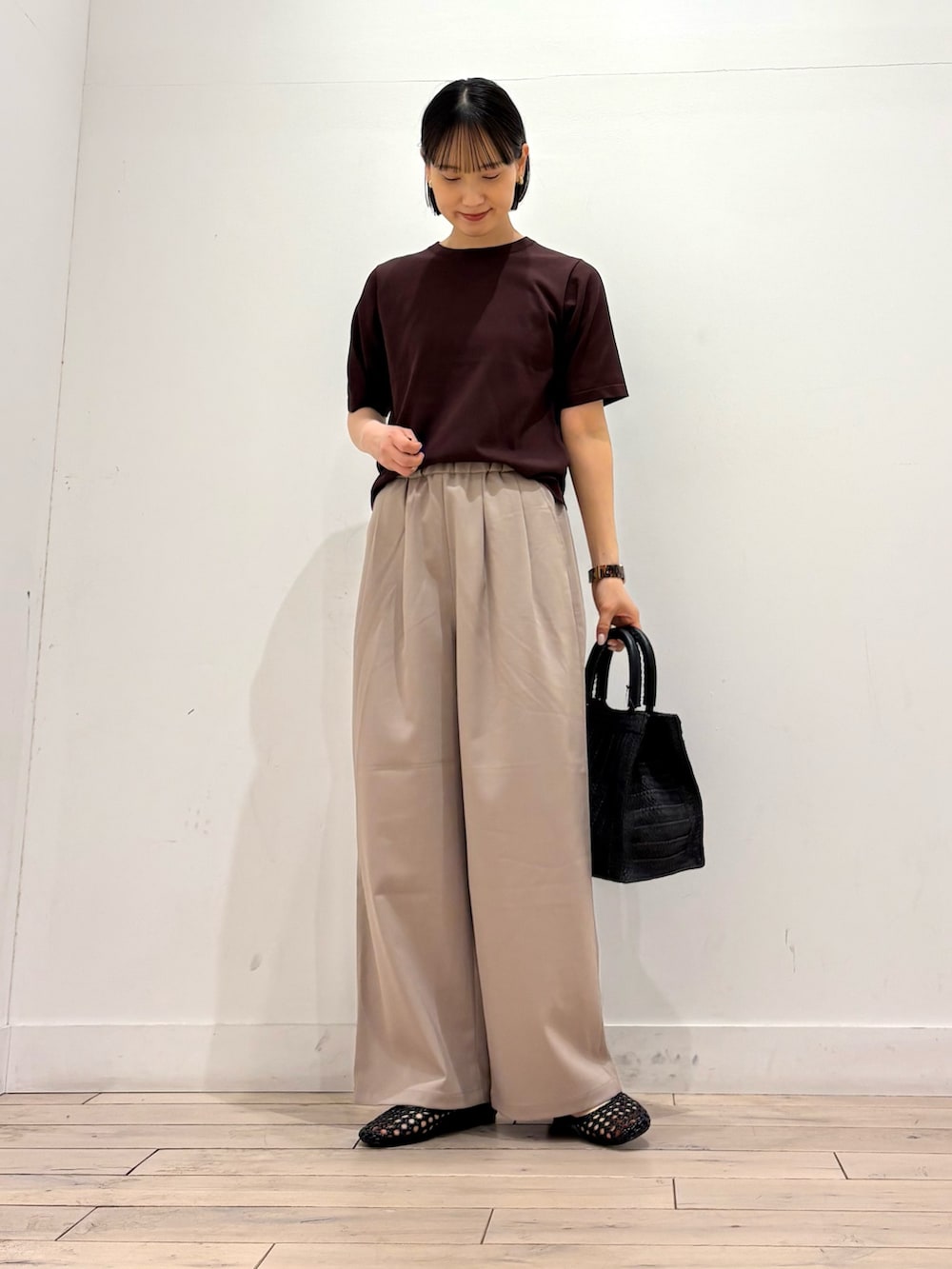 ブラウン系のTシャツ/カットソー、ベージュ系のその他パンツ、ブラック系のサンダルを着用したレディースの春コーディネートの2枚目の写真