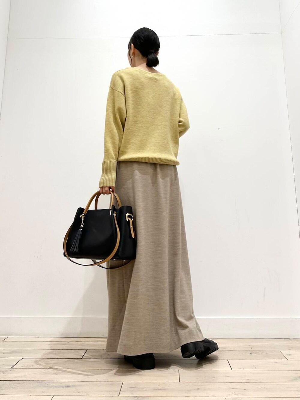 ブラック系のトートバッグ、ブラック系のその他アウター、ブラック系のブーツを着用したレディースの冬コーディネートの3枚目の写真