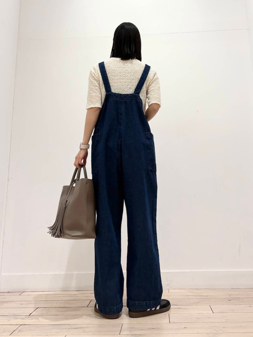 ブルー系のサロペット/オーバーオール、グレー系のトートバッグ、ホワイト系のノーカラージャケットを着用したレディースの春コーディネートの3枚目の写真