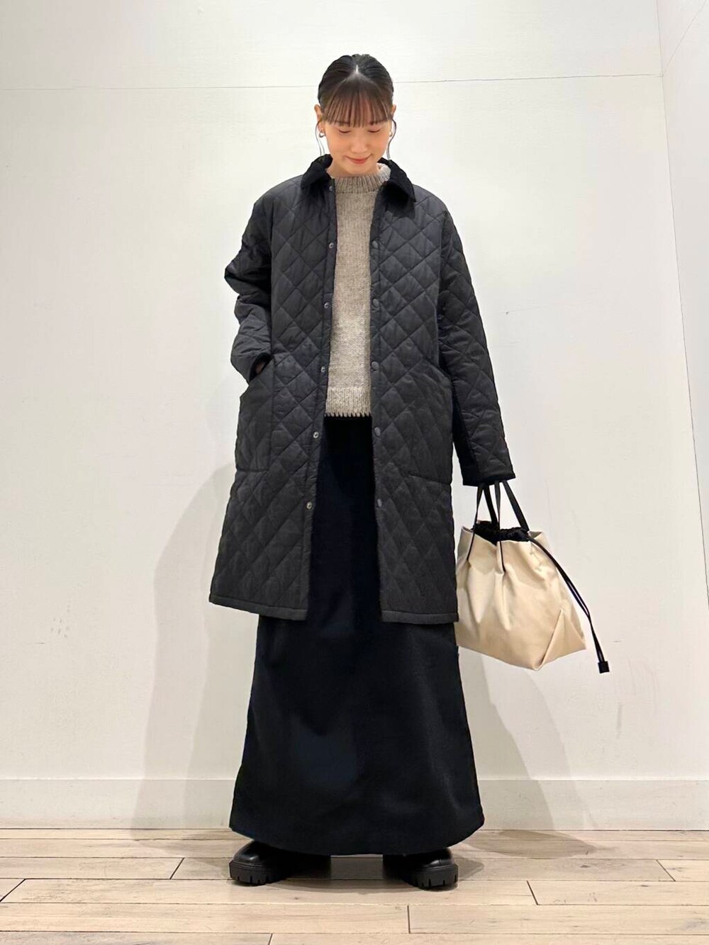 ホワイト系のショルダーバッグ、グレー系のニット/セーター、ブラック系のスカートを着用したレディースの冬コーディネートの6枚目の写真