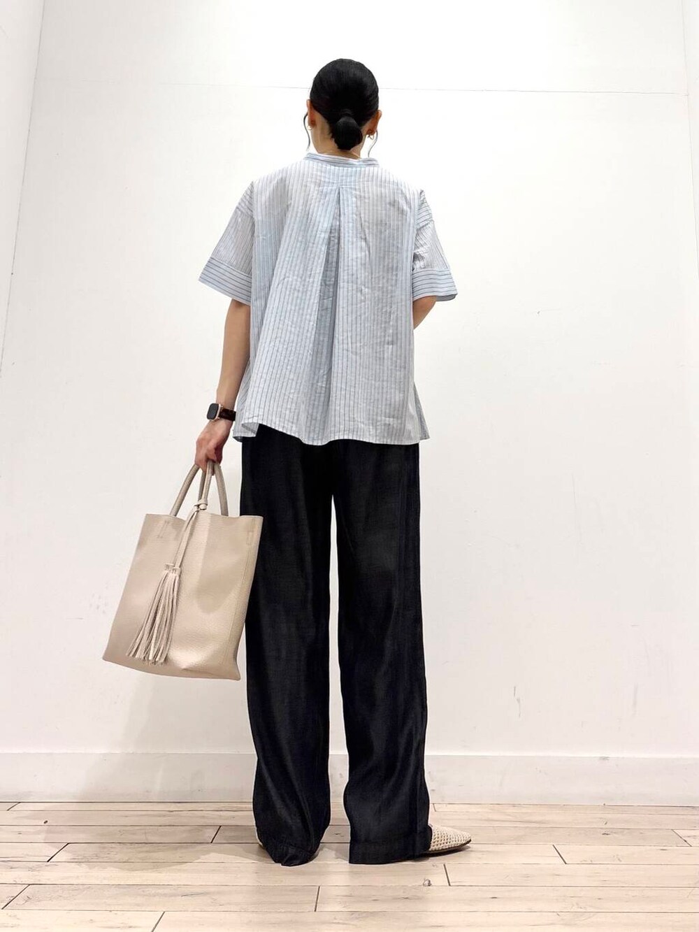 ホワイト系のトートバッグ、ホワイト系のバレエシューズ、ブラック系のデニムパンツを着用したレディースの夏コーディネートの4枚目の写真