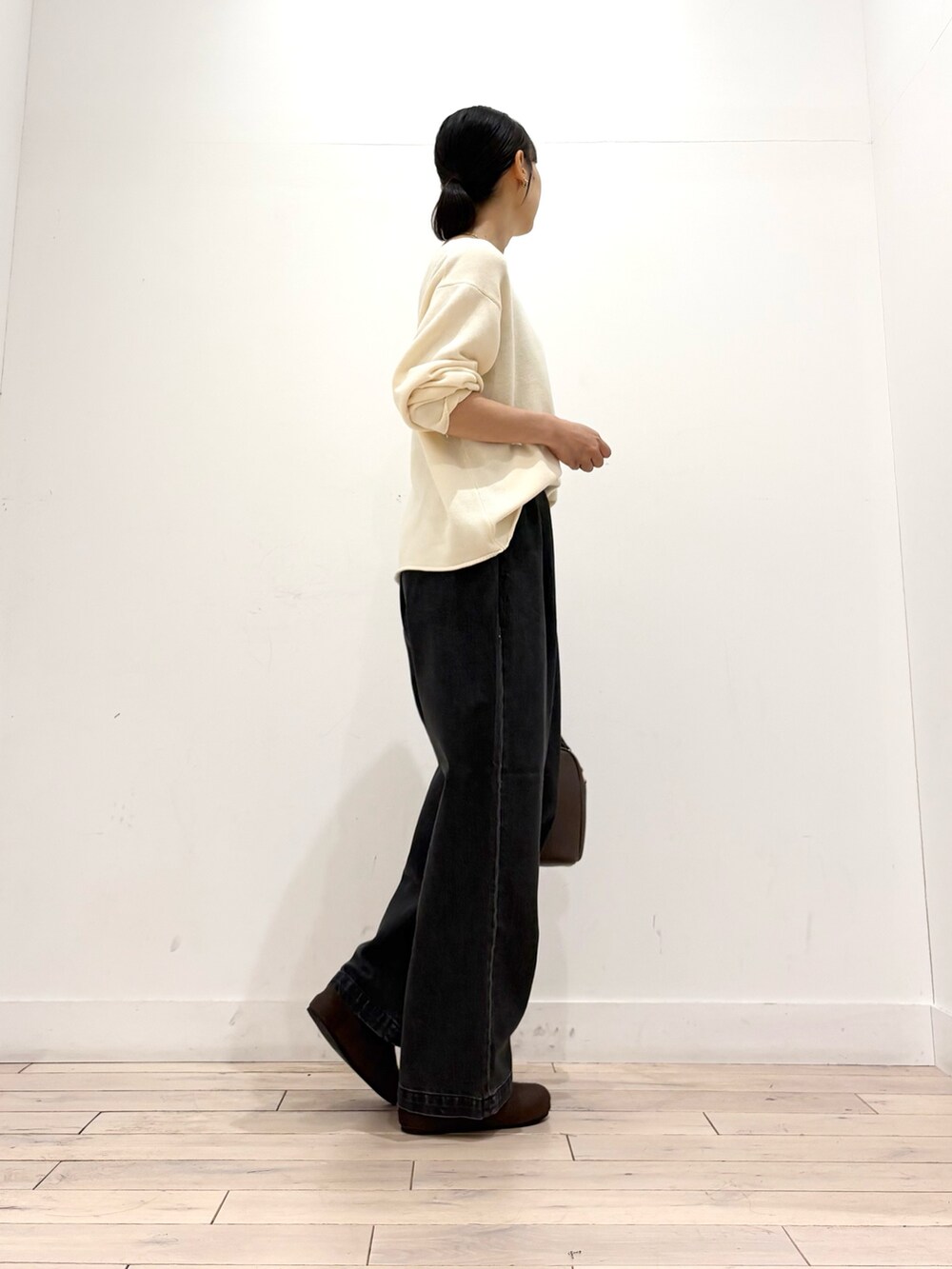 ホワイト系のニット/セーター、ブラック系のデニムパンツ、ブラウン系のショルダーバッグを着用したレディースの秋コーディネートの3枚目の写真