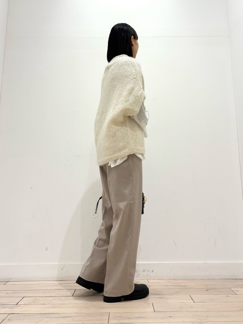 ホワイト系のニット/セーター、ホワイト系のシャツ/ブラウス、ブラック系のブーツを着用したレディースの冬コーディネートの4枚目の写真