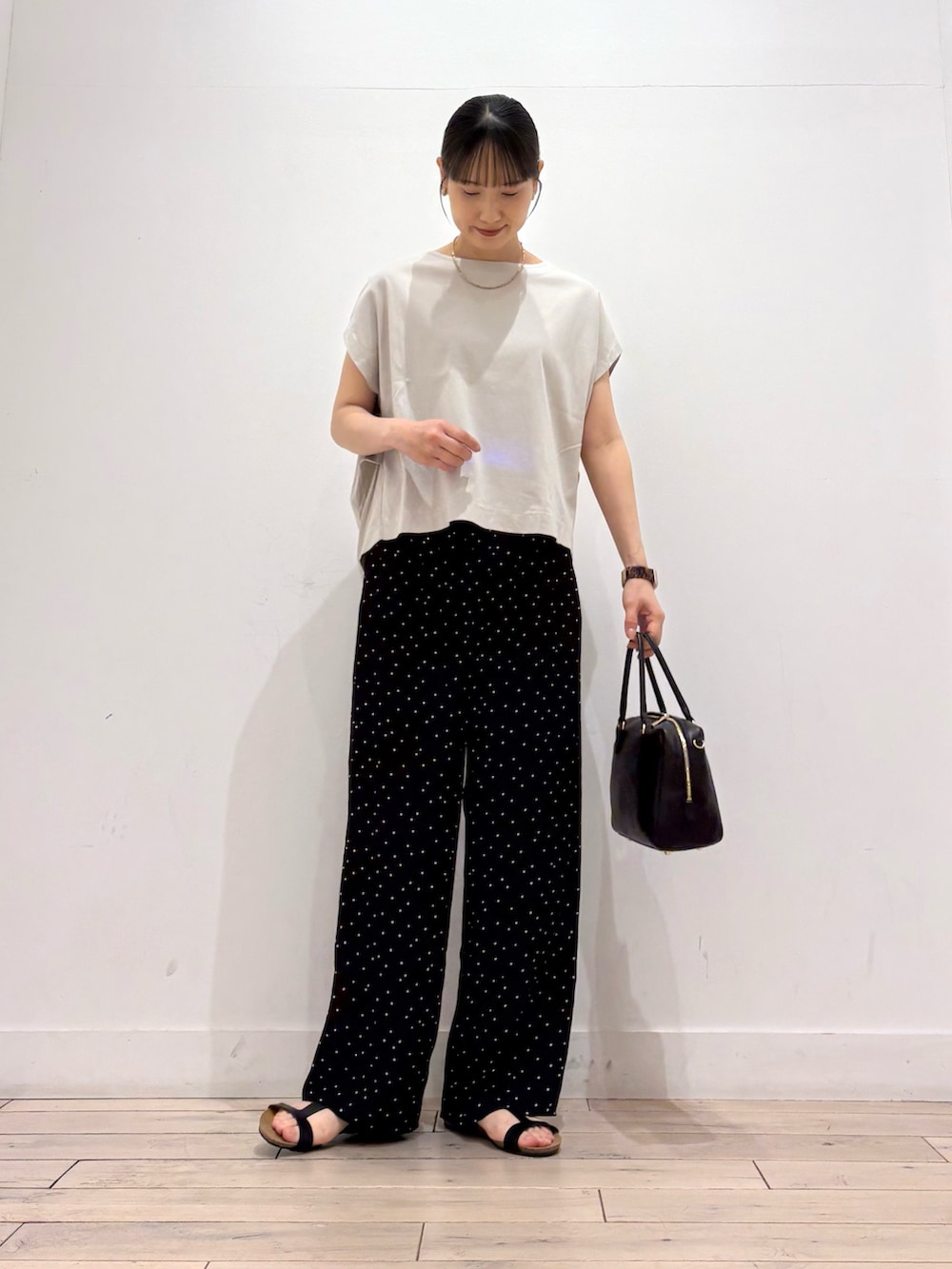 ブラック系のその他パンツ、ブラック系のボストンバッグ、ブラック系のサンダルを着用したレディースの夏コーディネートの2枚目の写真