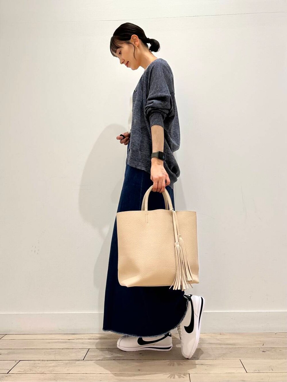 ホワイト系のトートバッグ、ホワイト系のタンクトップ、ブルー系のカーディガン/ボレロを着用したレディースの夏コーディネートの2枚目の写真