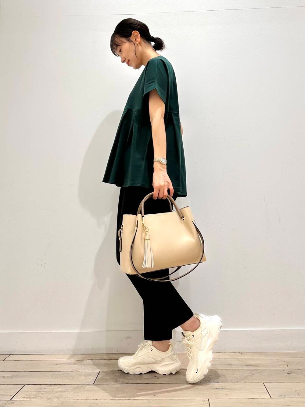 ホワイト系のトートバッグ、ホワイト系のスニーカー、グリーン系のTシャツ/カットソーを着用したレディースの夏コーディネートの2枚目の写真