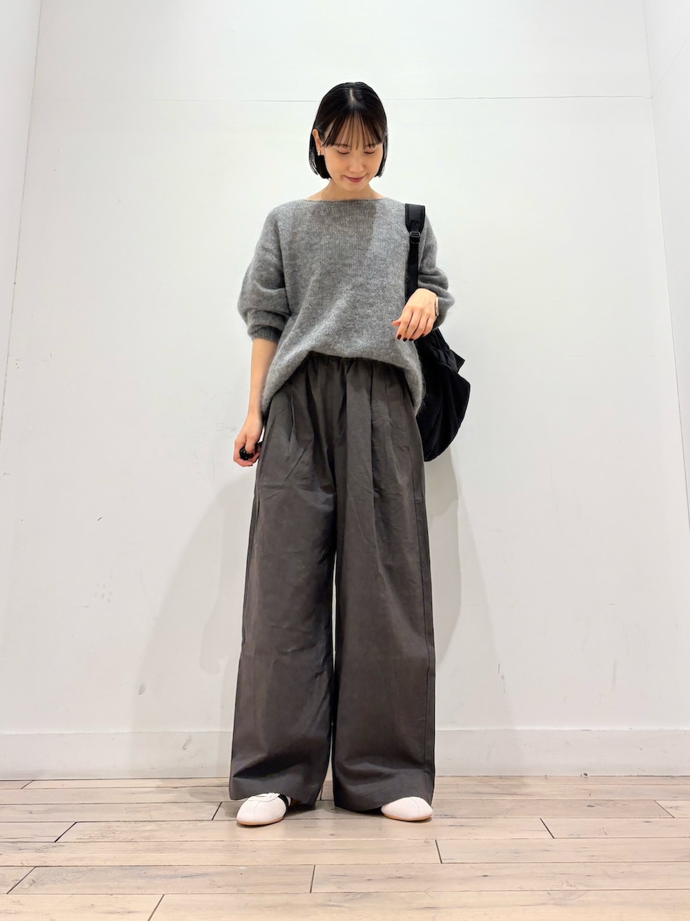 グレー系のニット/セーター、グレー系のその他パンツ、ホワイト系のスニーカーを着用したレディースの秋コーディネートの2枚目の写真