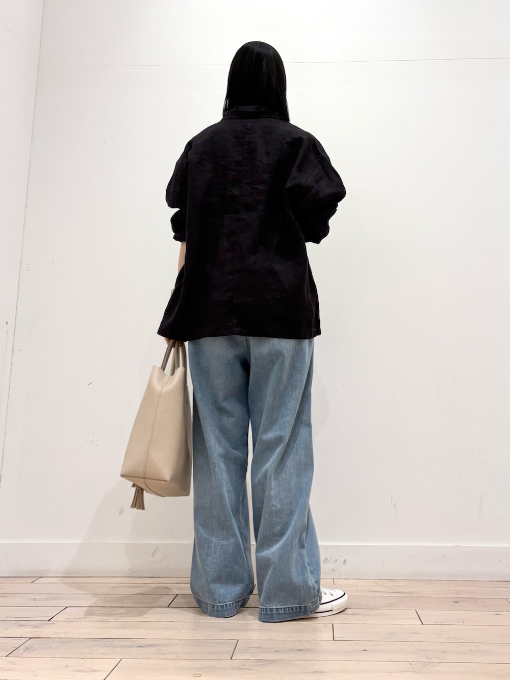 グレー系のカバーオール、ホワイト系のトートバッグ、ホワイト系のスニーカーを着用したレディースの春コーディネートの4枚目の写真