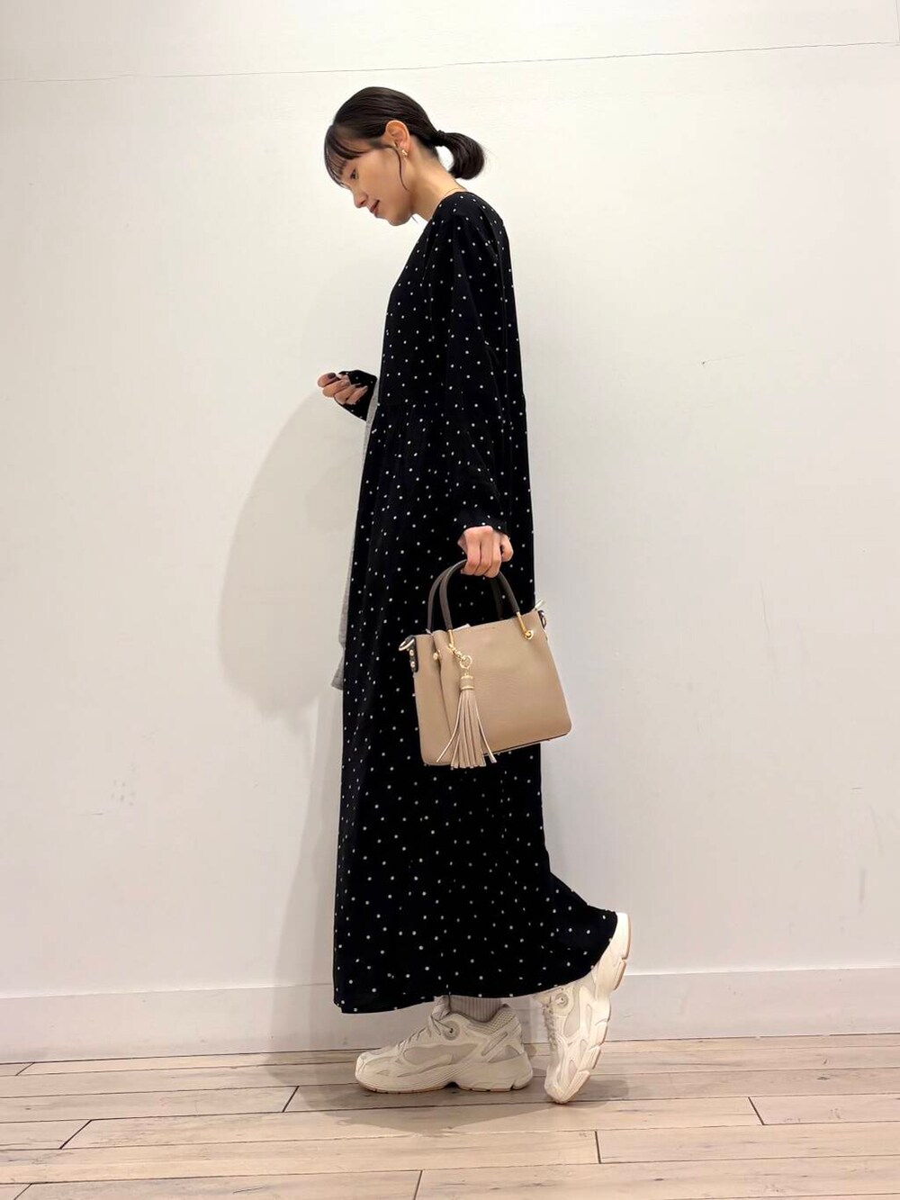 ベージュ系のトートバッグ、ブラック系のワンピース、グレー系のパーカーを着用したレディースの春コーディネートの4枚目の写真