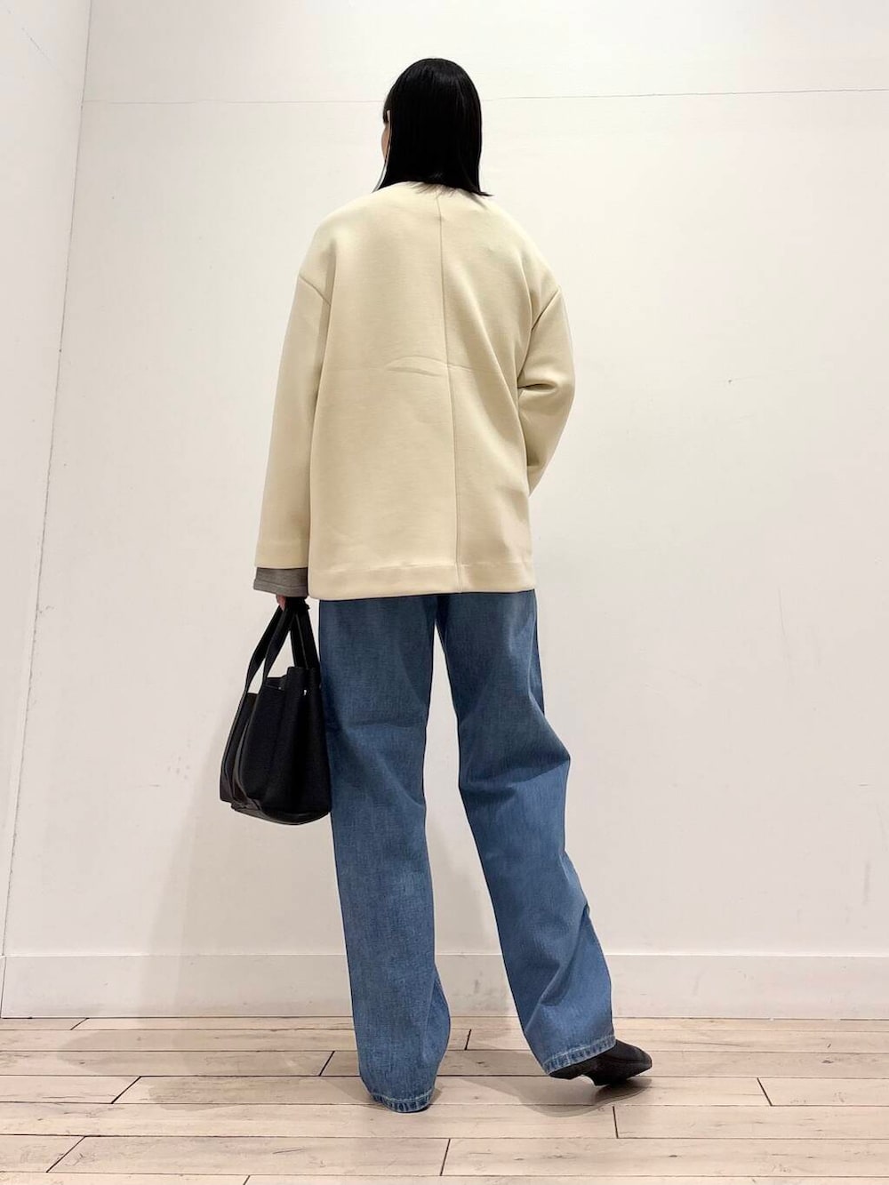 ブラック系のトートバッグ、グレー系のカーディガン/ボレロ、ホワイト系のノーカラージャケットを着用したレディースの冬コーディネートの3枚目の写真