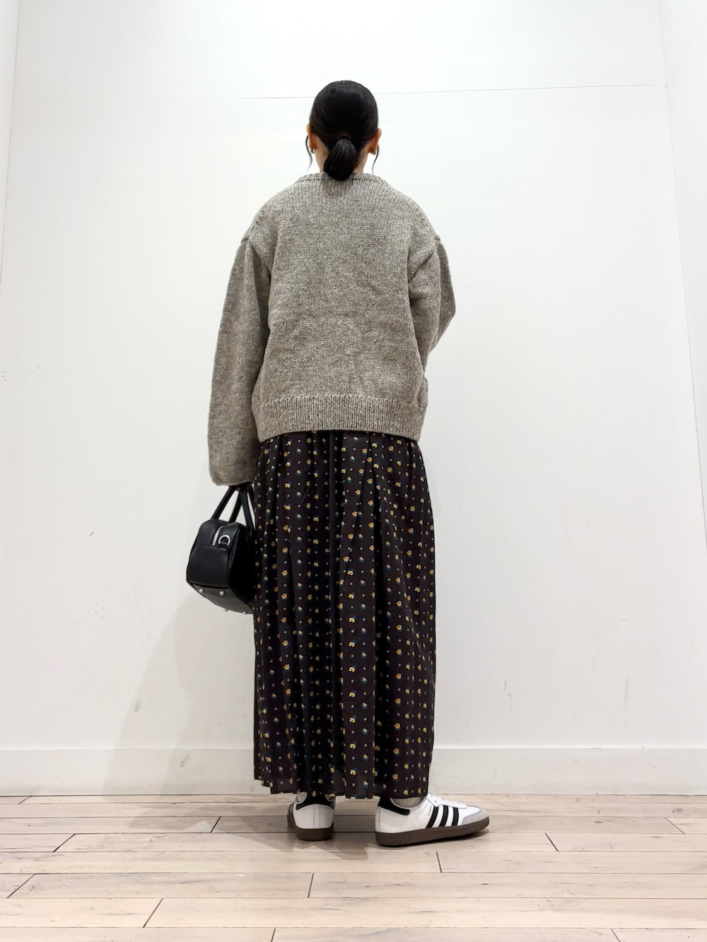 グレー系のニット/セーター、グレー系のTシャツ/カットソー、ブラック系のスカートを着用したレディースの秋コーディネートの4枚目の写真