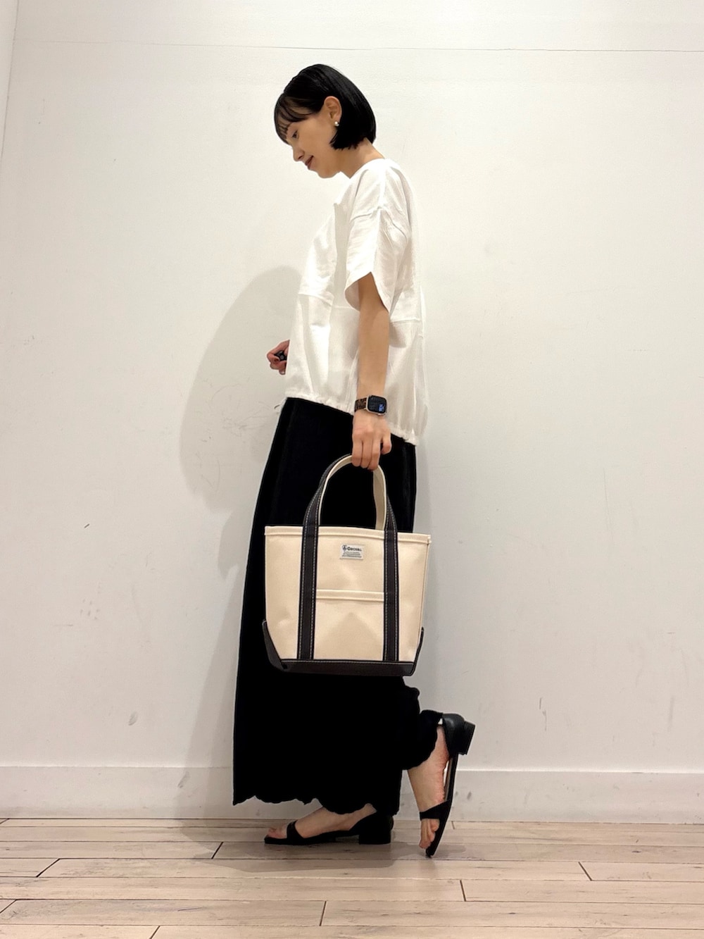 ホワイト系のTシャツ/カットソー、ブラック系のその他パンツ、グレー系のトートバッグを着用したレディースの春コーディネートの2枚目の写真