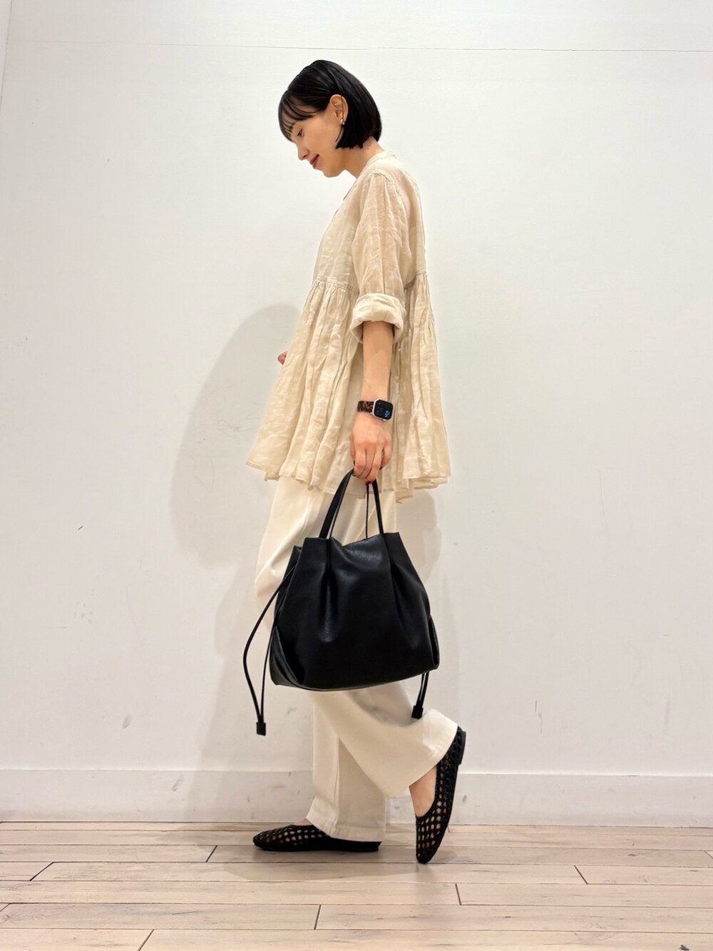 ベージュ系のシャツ/ブラウス、ベージュ系のデニムパンツ、ブラック系のショルダーバッグを着用したレディースの春コーディネートの4枚目の写真