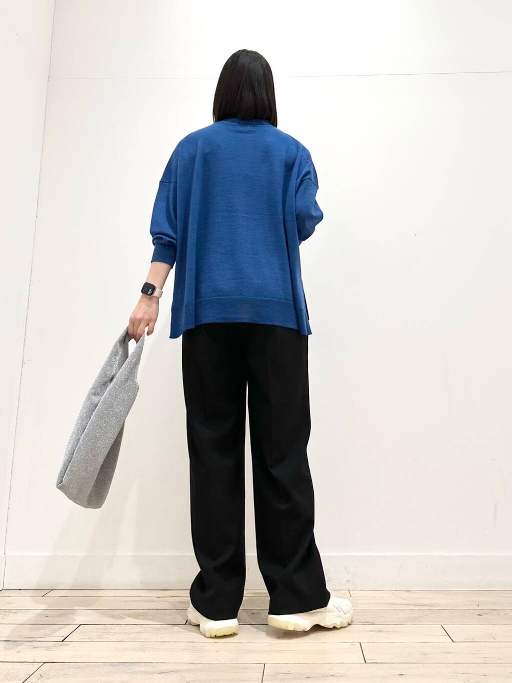 ホワイト系のスニーカー、グリーン系のニット/セーター、シルバー系のトートバッグを着用したレディースの冬コーディネートの7枚目の写真