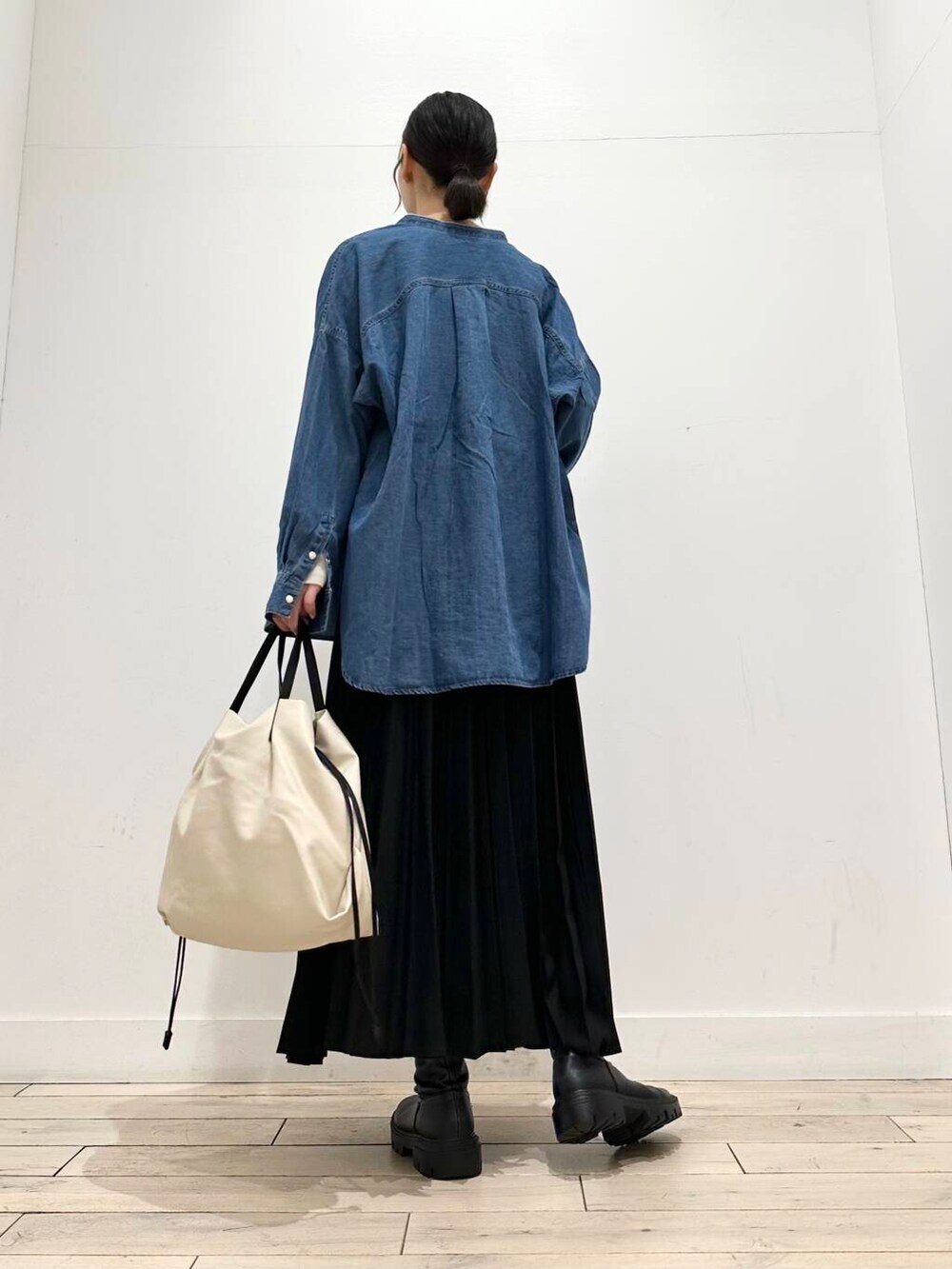 ホワイト系のトートバッグ、ブラック系のブーツ、ベージュ系のTシャツ/カットソーを着用したレディースの冬コーディネートの4枚目の写真