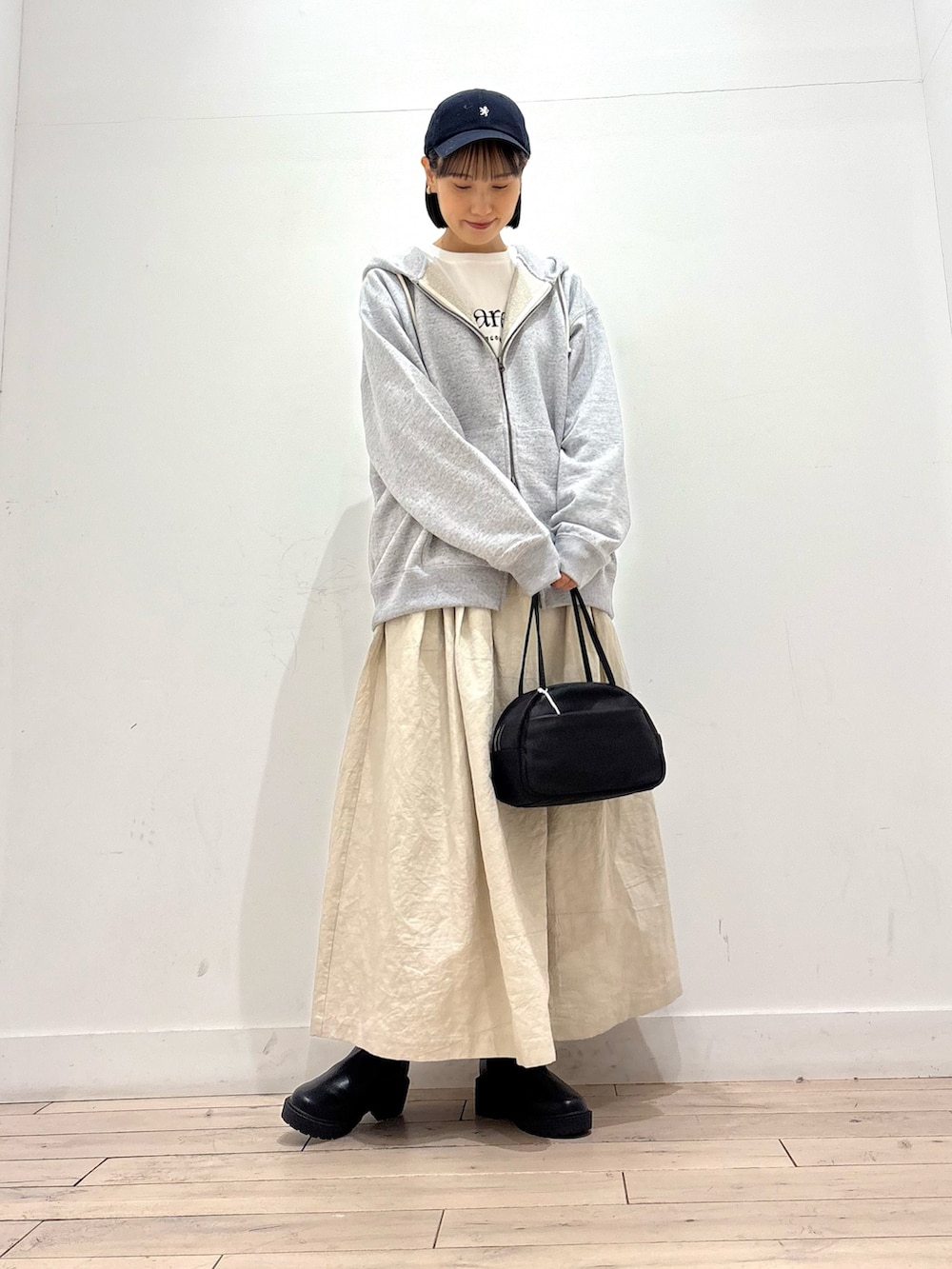 ホワイト系のTシャツ/カットソー、グレー系のパーカー、ブラック系のボストンバッグを着用したレディースの秋コーディネートの2枚目の写真