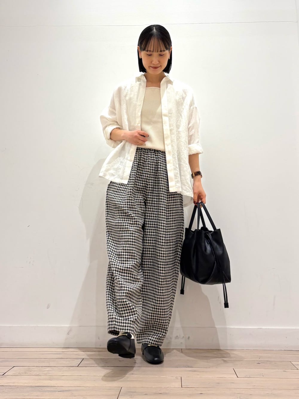 ホワイト系のタンクトップ、ホワイト系のシャツ/ブラウス、ブラック系のショルダーバッグを着用したレディースの春コーディネートの2枚目の写真