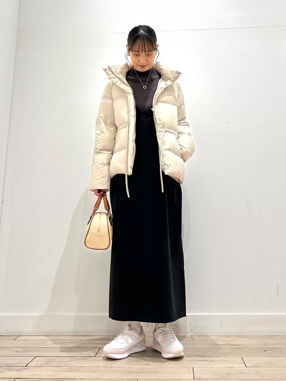 ブラウン系のニット/セーター、ホワイト系のダウンジャケット/コート、イエロー系のボストンバッグを着用したレディースの冬コーディネートの5枚目の写真