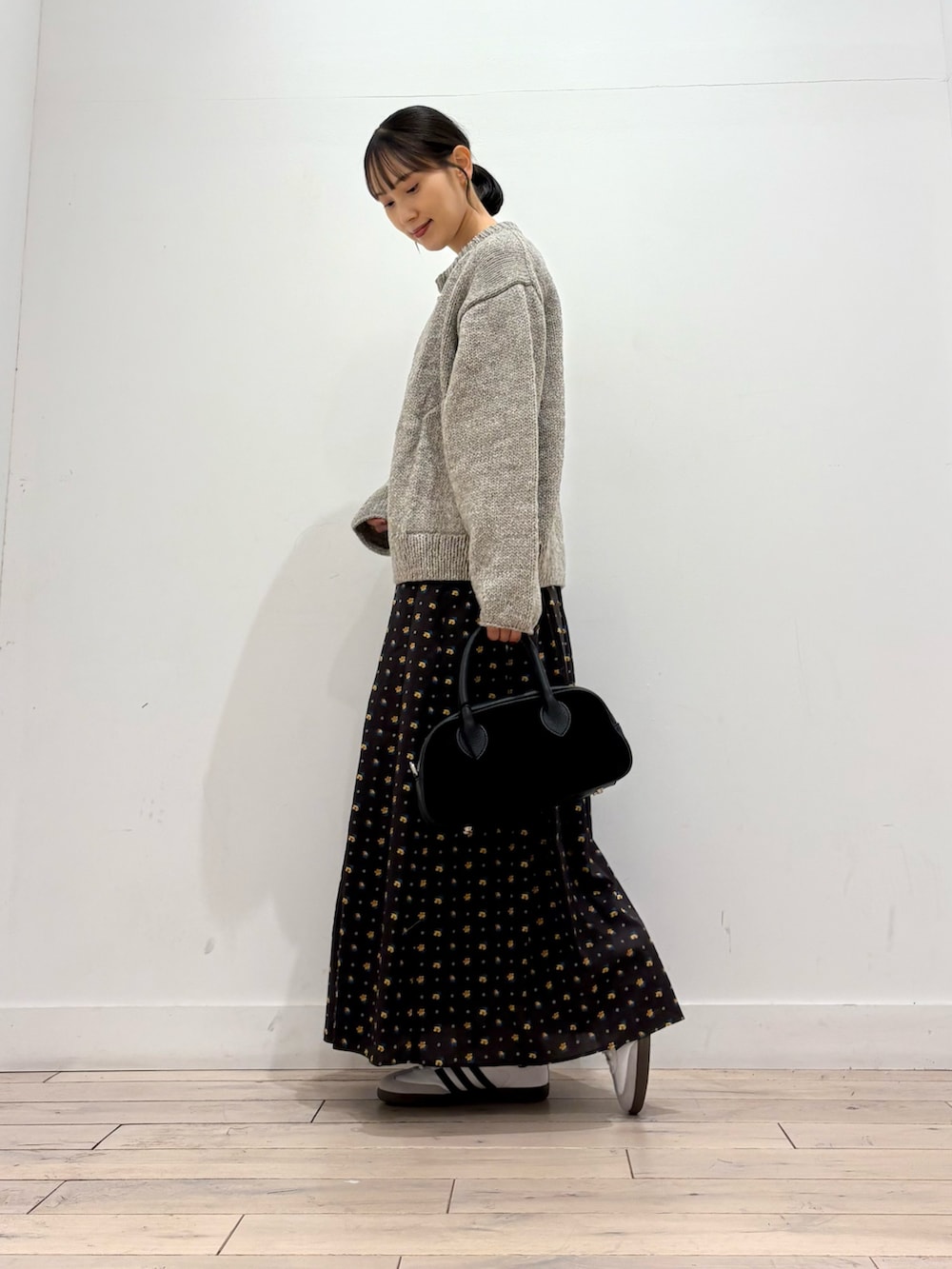 グレー系のニット/セーター、グレー系のTシャツ/カットソー、ブラック系のスカートを着用したレディースの秋コーディネートの3枚目の写真