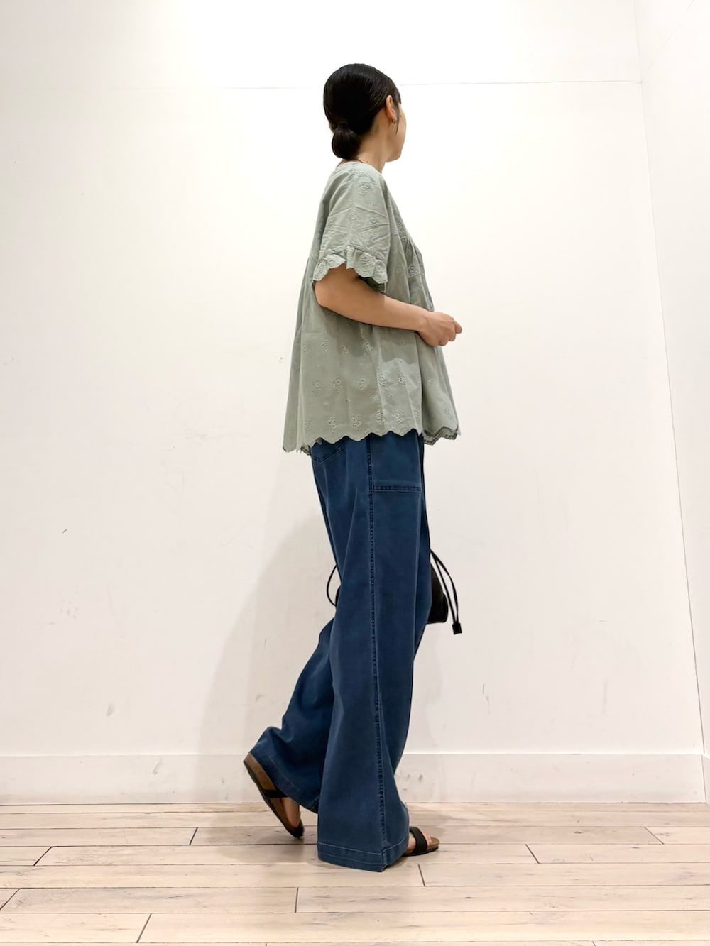 グリーン系のシャツ/ブラウス、ブルー系のデニムパンツ、ブラック系のショルダーバッグを着用したレディースの夏コーディネートの3枚目の写真