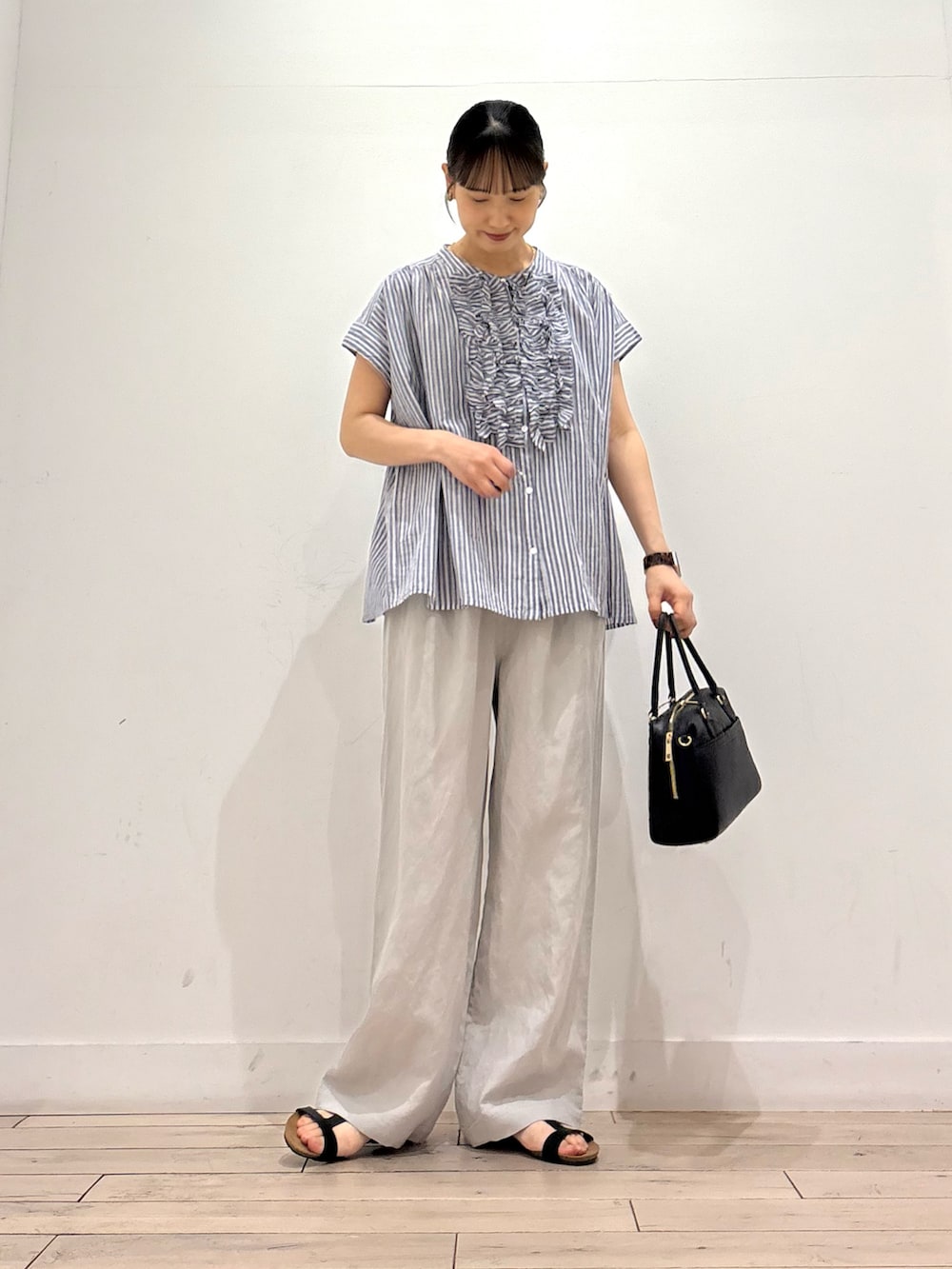 ブルー系のシャツ/ブラウス、ベージュ系のその他パンツ、ブラック系のボストンバッグを着用したレディースの夏コーディネートの2枚目の写真