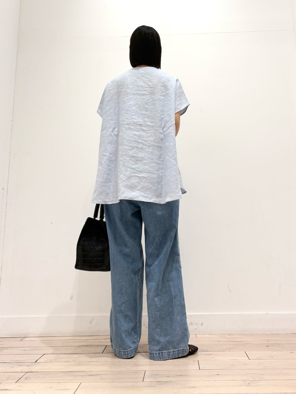 ブルー系のシャツ/ブラウス、ブルー系のデニムパンツ、ブラック系のハンドバッグを着用したレディースの春コーディネートの4枚目の写真
