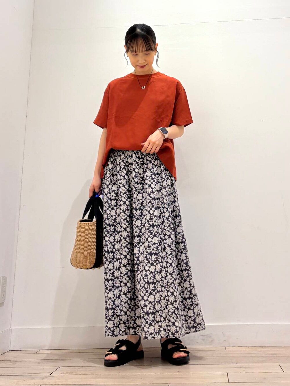 ベージュ系のハンドバッグ、オレンジ系のシャツ/ブラウス、ブラック系のサンダルを着用したレディースの春コーディネートの2枚目の写真