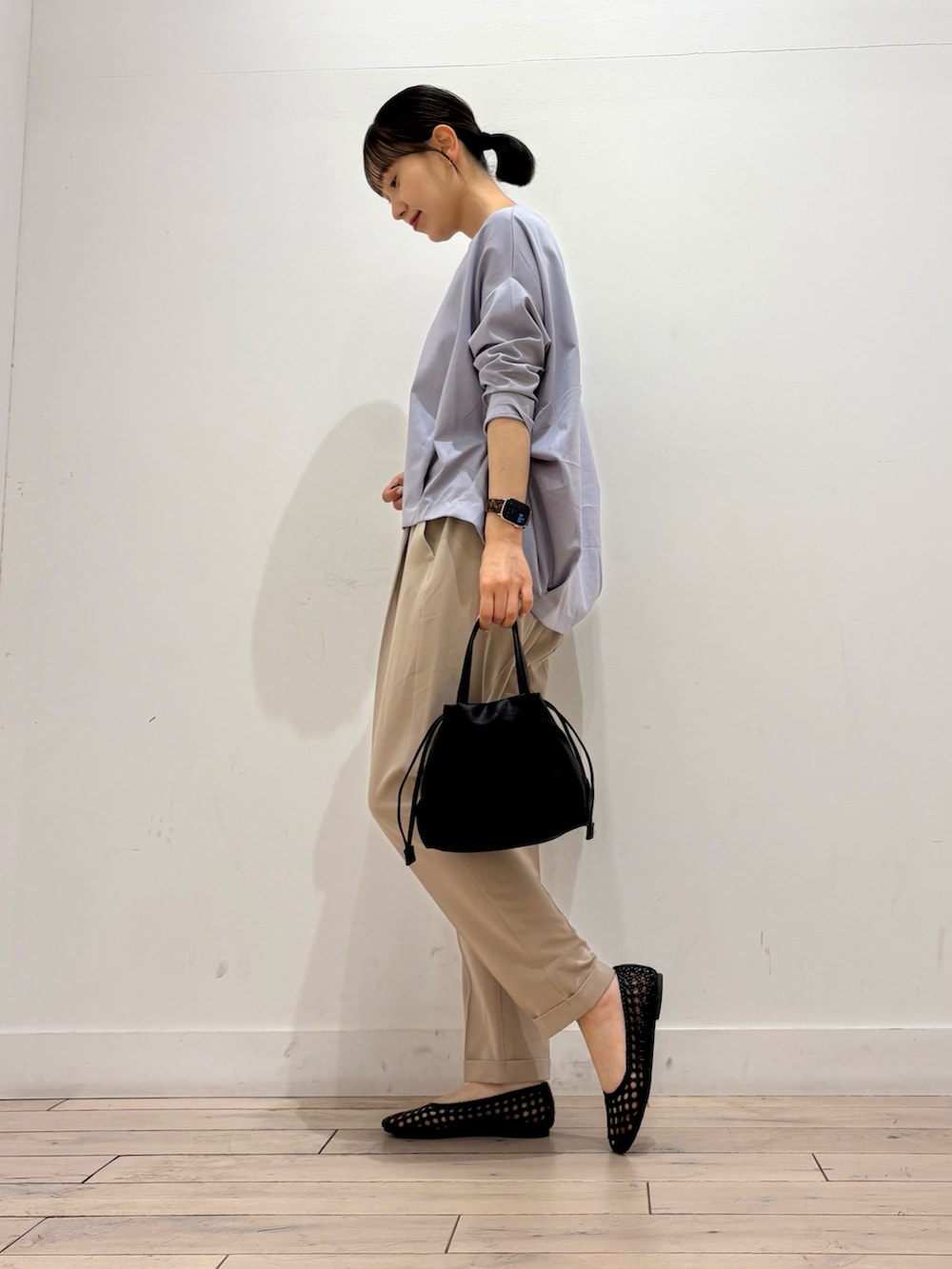 パープル系のTシャツ/カットソー、ベージュ系のその他パンツ、ブラック系のショルダーバッグを着用したレディースの春コーディネートの3枚目の写真