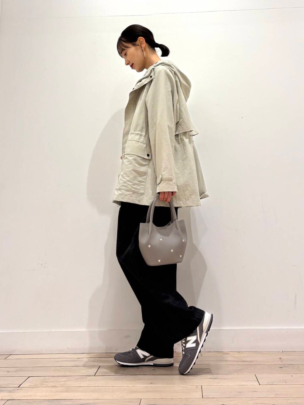 ベージュ系のマウンテンパーカー、ブラック系のデニムパンツ、グレー系のショルダーバッグを着用したレディースの春コーディネートの3枚目の写真