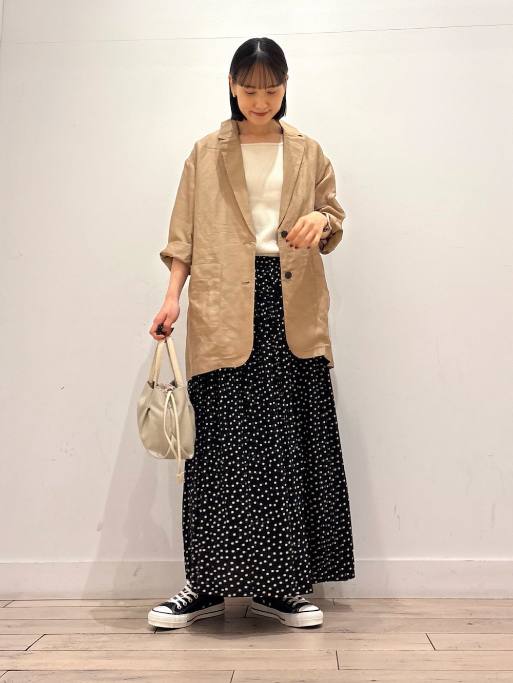 ホワイト系のタンクトップ、ブラック系のジャケット/アウター、ブラック系のスニーカーを着用したレディースの春コーディネートの2枚目の写真