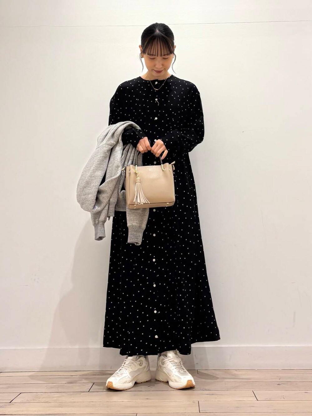ベージュ系のトートバッグ、ブラック系のワンピース、グレー系のパーカーを着用したレディースの春コーディネートの3枚目の写真
