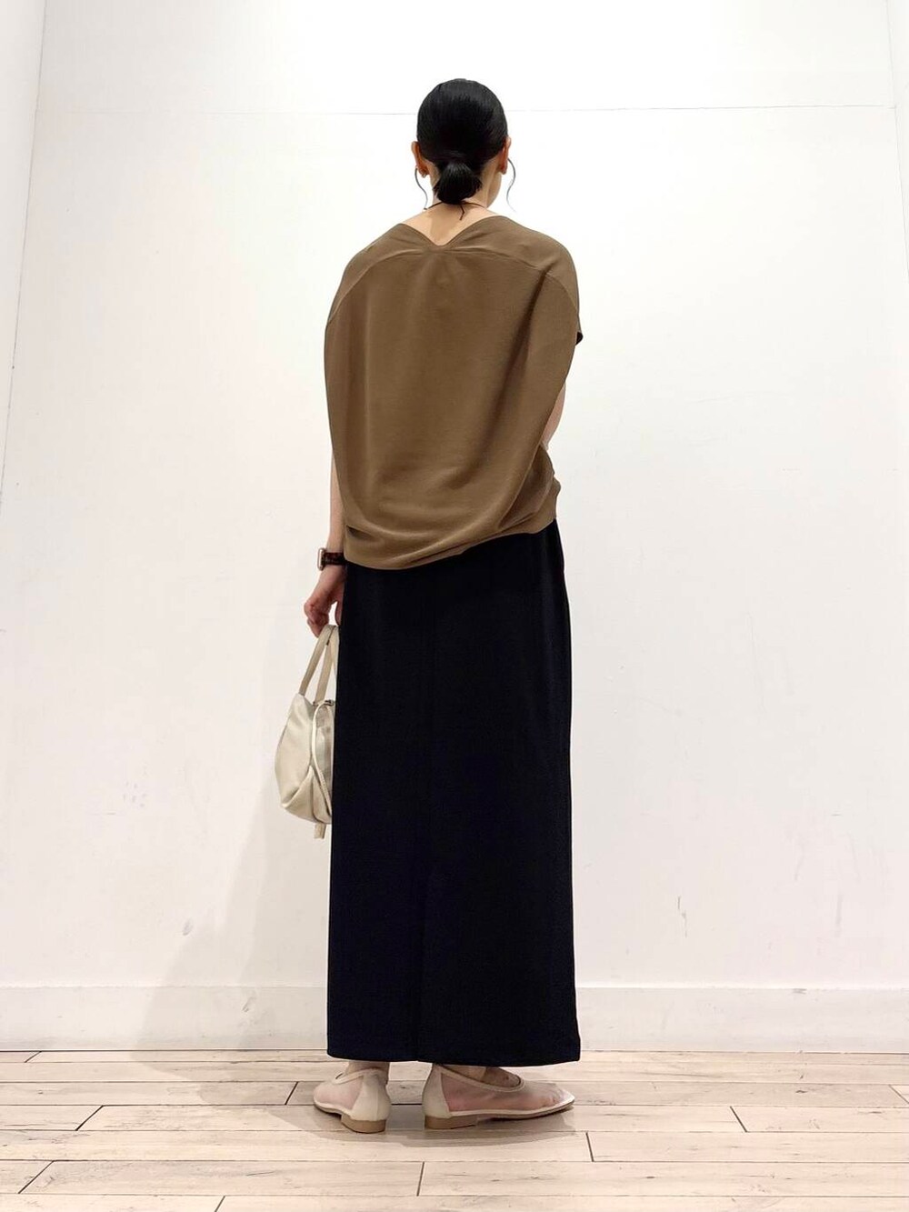 ホワイト系のバレエシューズ、ブラック系のスカート、ホワイト系のショルダーバッグを着用したレディースの夏コーディネートの4枚目の写真