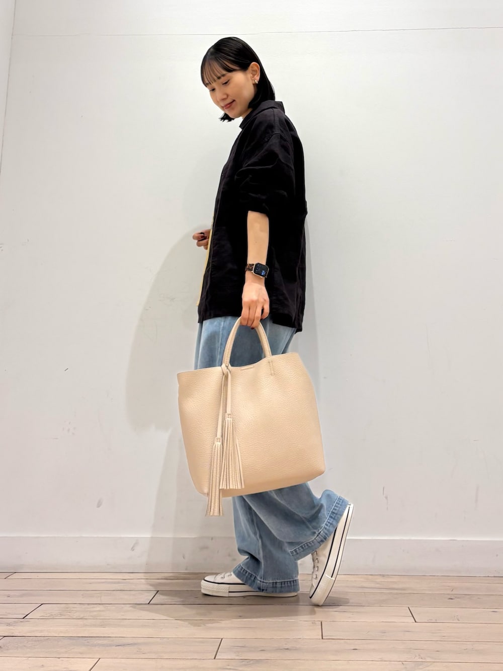 グレー系のカバーオール、ホワイト系のトートバッグ、ホワイト系のスニーカーを着用したレディースの春コーディネートの3枚目の写真