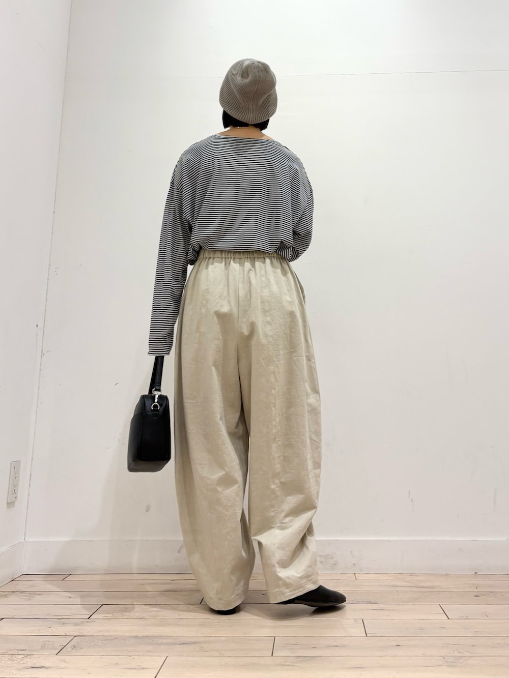 グレー系のダウンジャケット/コート、ブラック系のTシャツ/カットソー、ホワイト系のその他パンツを着用したレディースの秋コーディネートの7枚目の写真