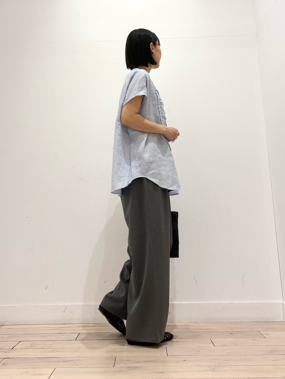 ブルー系のシャツ/ブラウス、グレー系のその他パンツ、ブラック系のハンドバッグを着用したレディースの春コーディネートの4枚目の写真