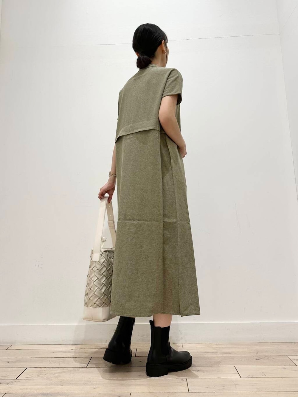 ホワイト系のトートバッグ、グリーン系のワンピース、ブラック系のブーツを着用したレディースの夏コーディネートの5枚目の写真