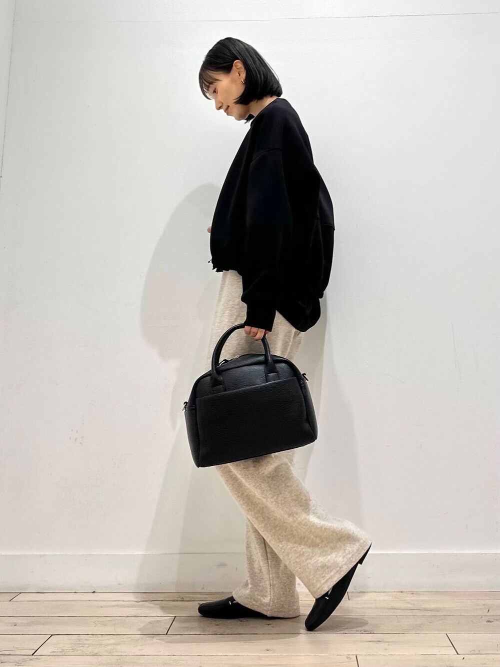 ブラック系のローファー、ブラック系のTシャツ/カットソー、ブラック系のボストンバッグを着用したレディースの秋コーディネートの5枚目の写真