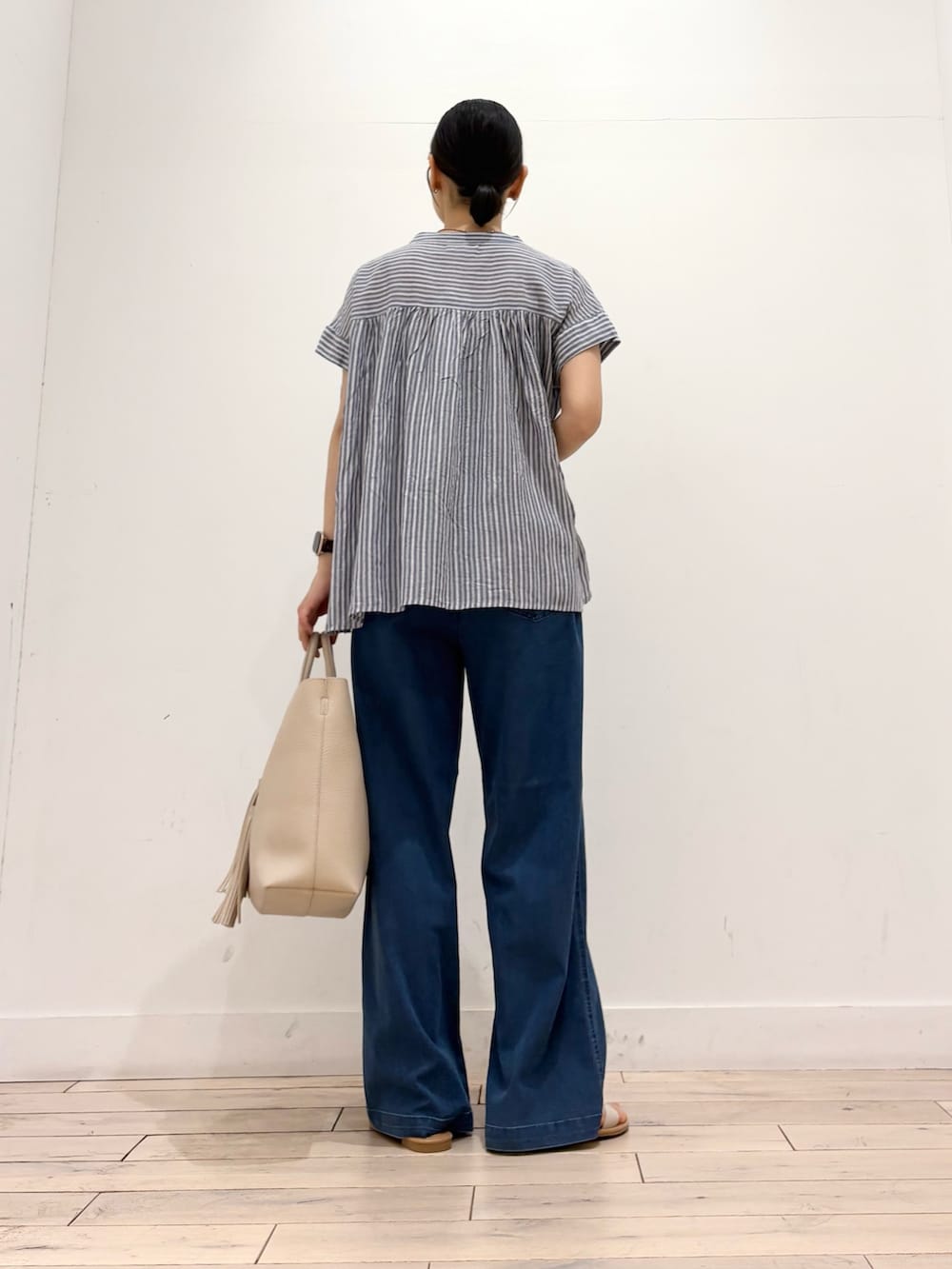 ブルー系のシャツ/ブラウス、ブルー系のデニムパンツ、ホワイト系のトートバッグを着用したレディースの夏コーディネートの4枚目の写真