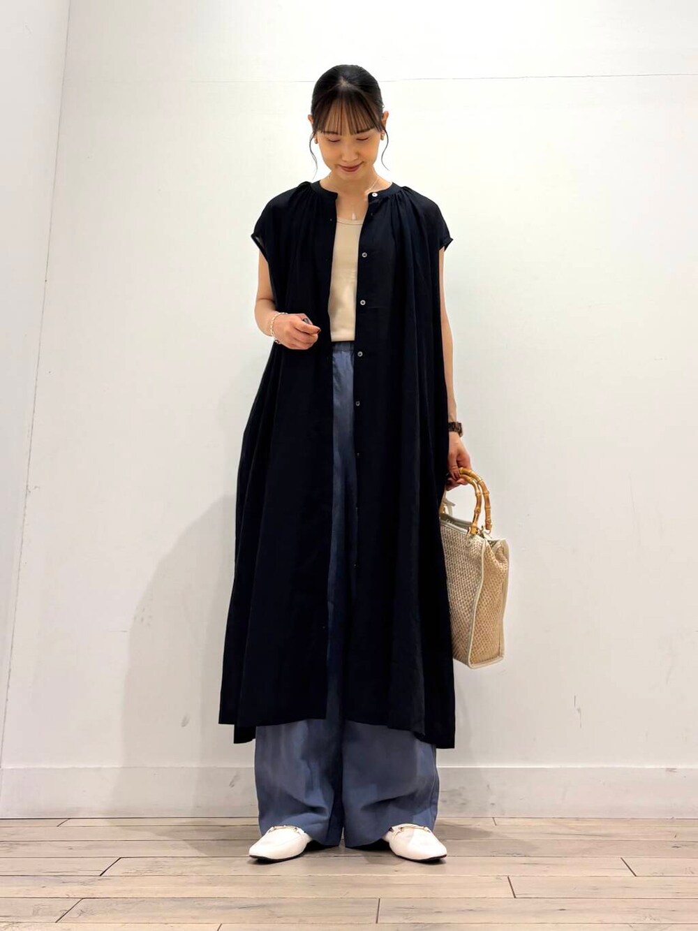 ベージュ系のタンクトップ、ホワイト系のローファー、ホワイト系のショルダーバッグを着用したレディースの夏コーディネートの3枚目の写真