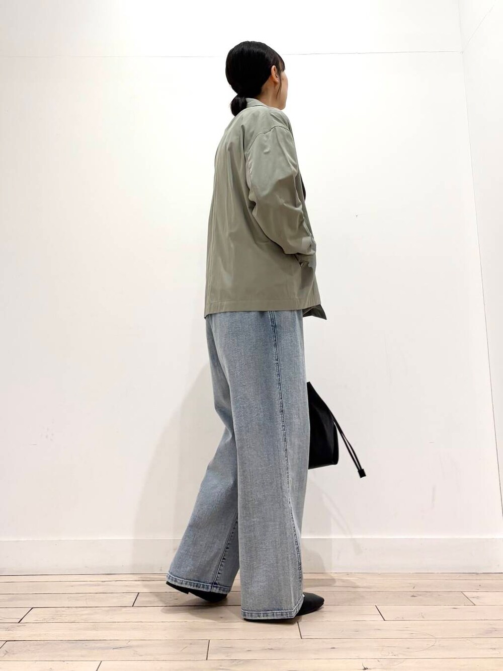 ブルー系のデニムパンツ、グリーン系のその他アウター、ブラック系のパンプスを着用したレディースの春コーディネートの7枚目の写真