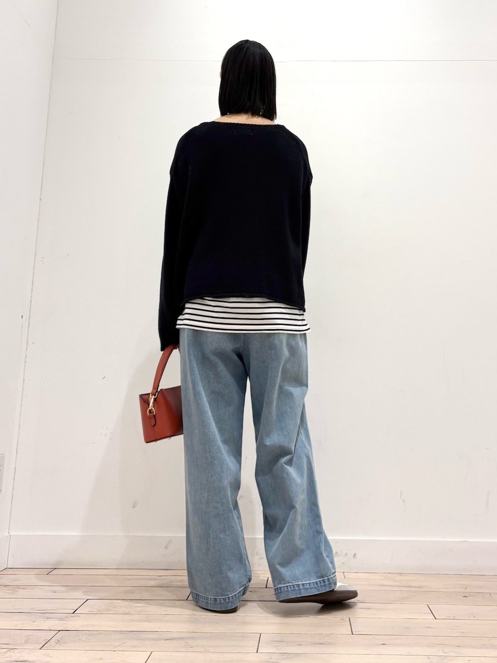 ブラック系のカーディガン/ボレロ、ブルー系のデニムパンツ、ホワイト系のスニーカーを着用したレディースの冬コーディネートの4枚目の写真