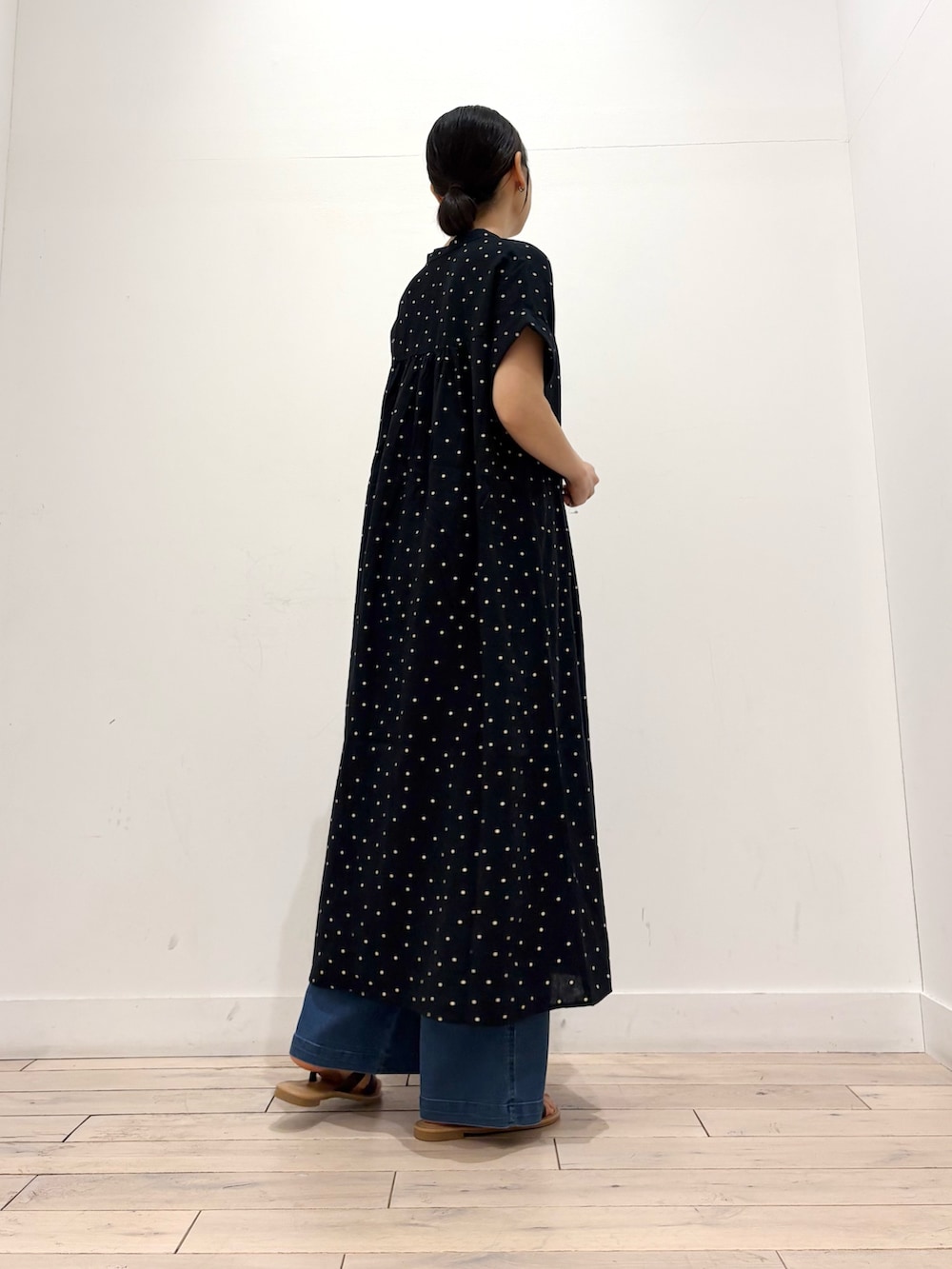 ブルー系のデニムパンツ、ブラウン系のサンダル、ブラック系のワンピースを着用したレディースの夏コーディネートの3枚目の写真